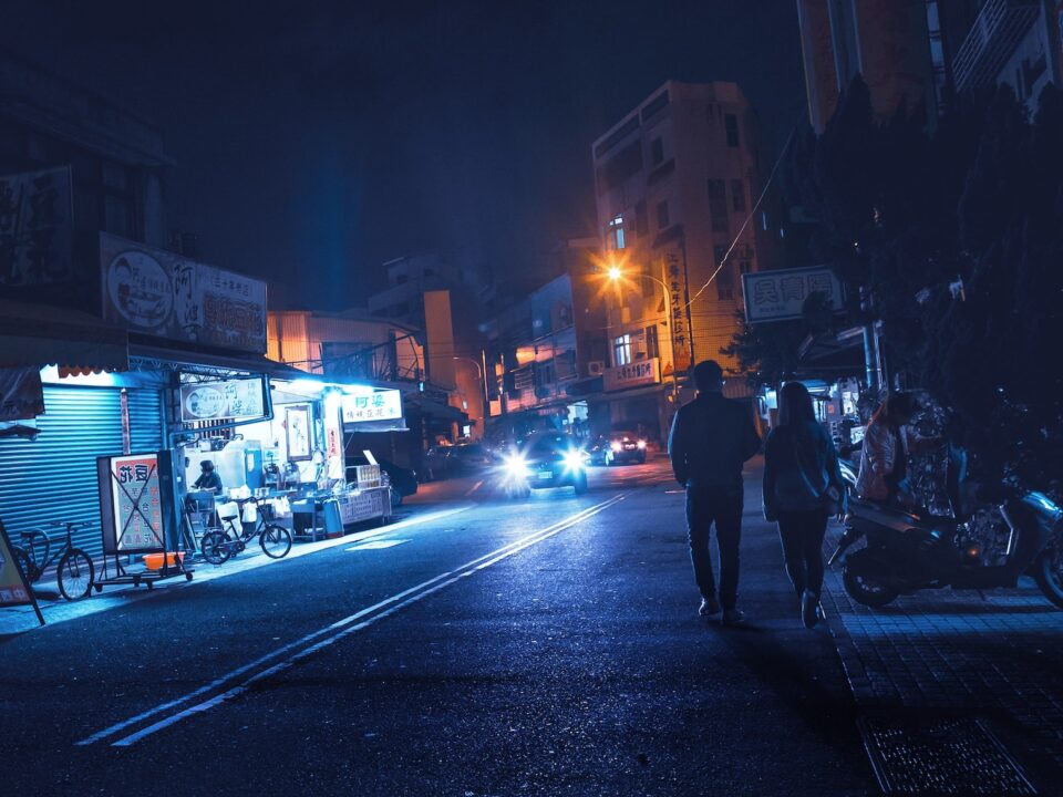 man and woman walking on road near building