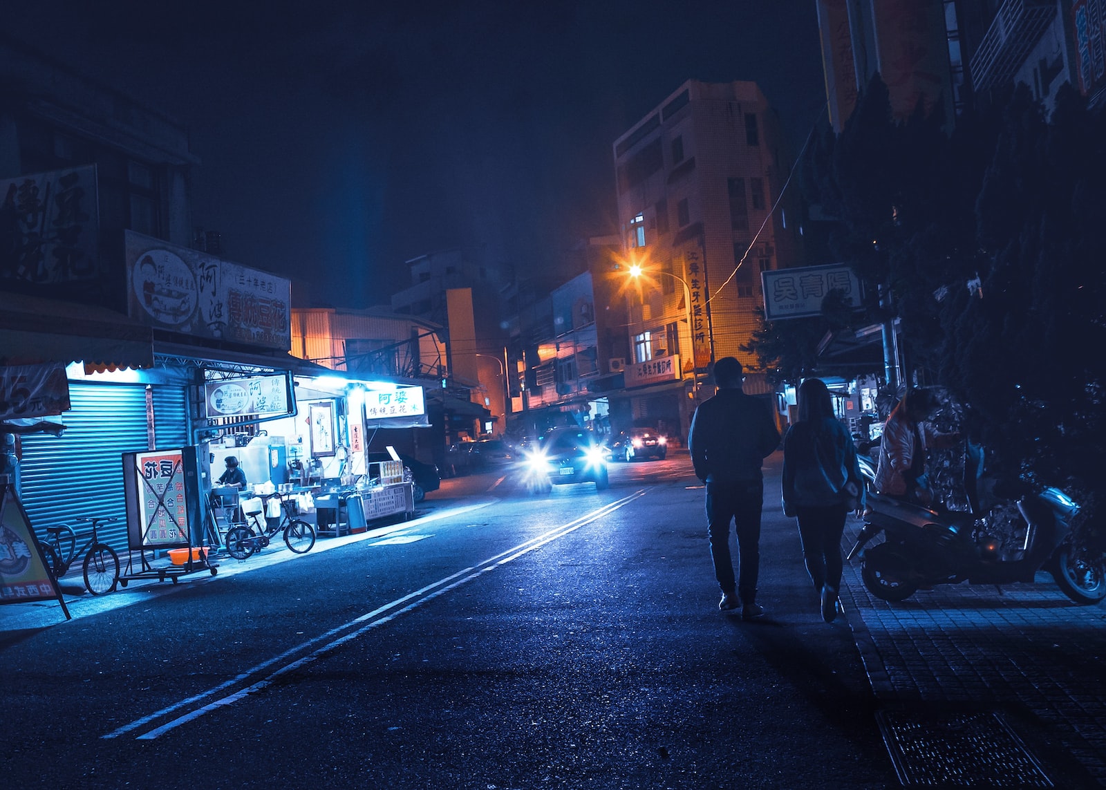 man and woman walking on road near building