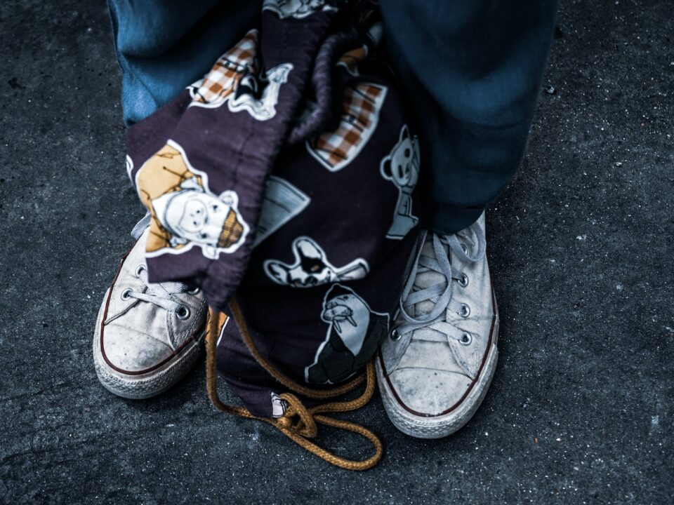 fabric drawstring backpack between man's feet