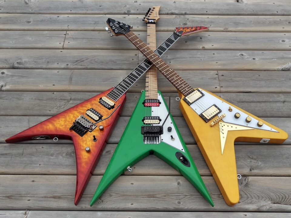 three assorted-color flying V electric guitars