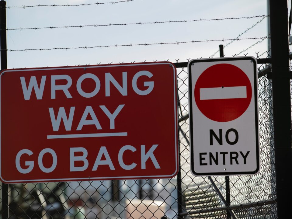 a red sign that says wrong way go back and no entry