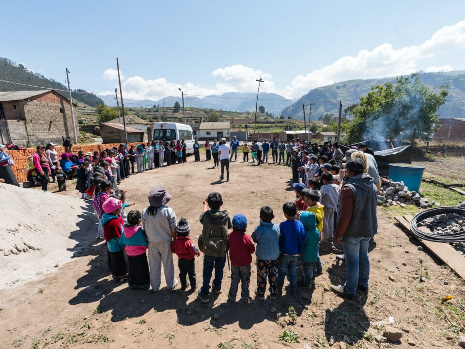 people standing forming circle near house under blue sky during daytime