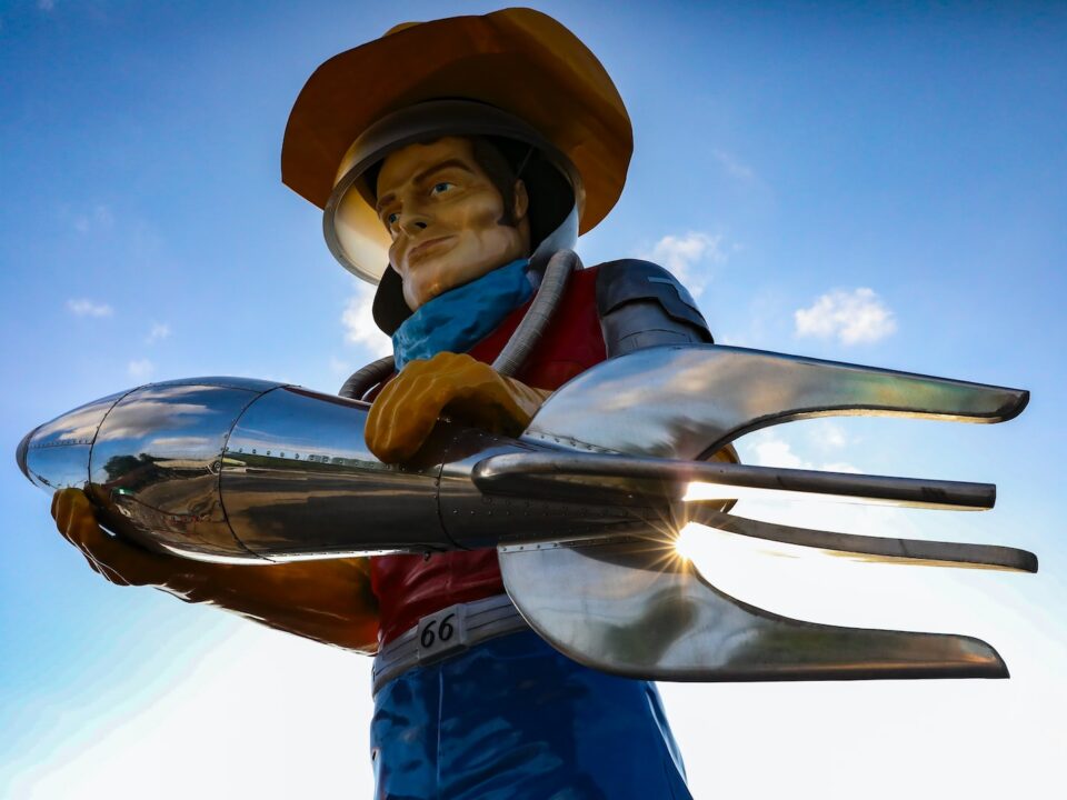 a statue of a man holding a giant fork