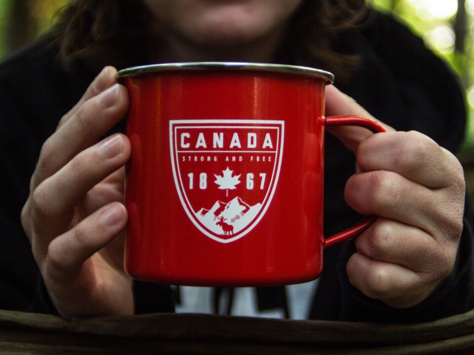 person holding red metal mug