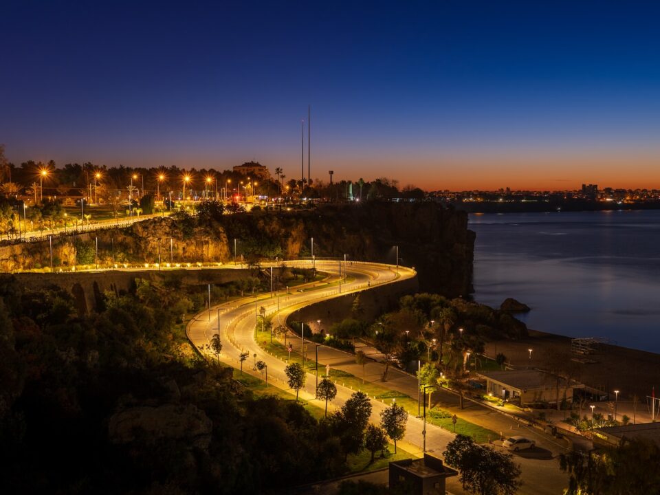 a night time view of a road near a body of water