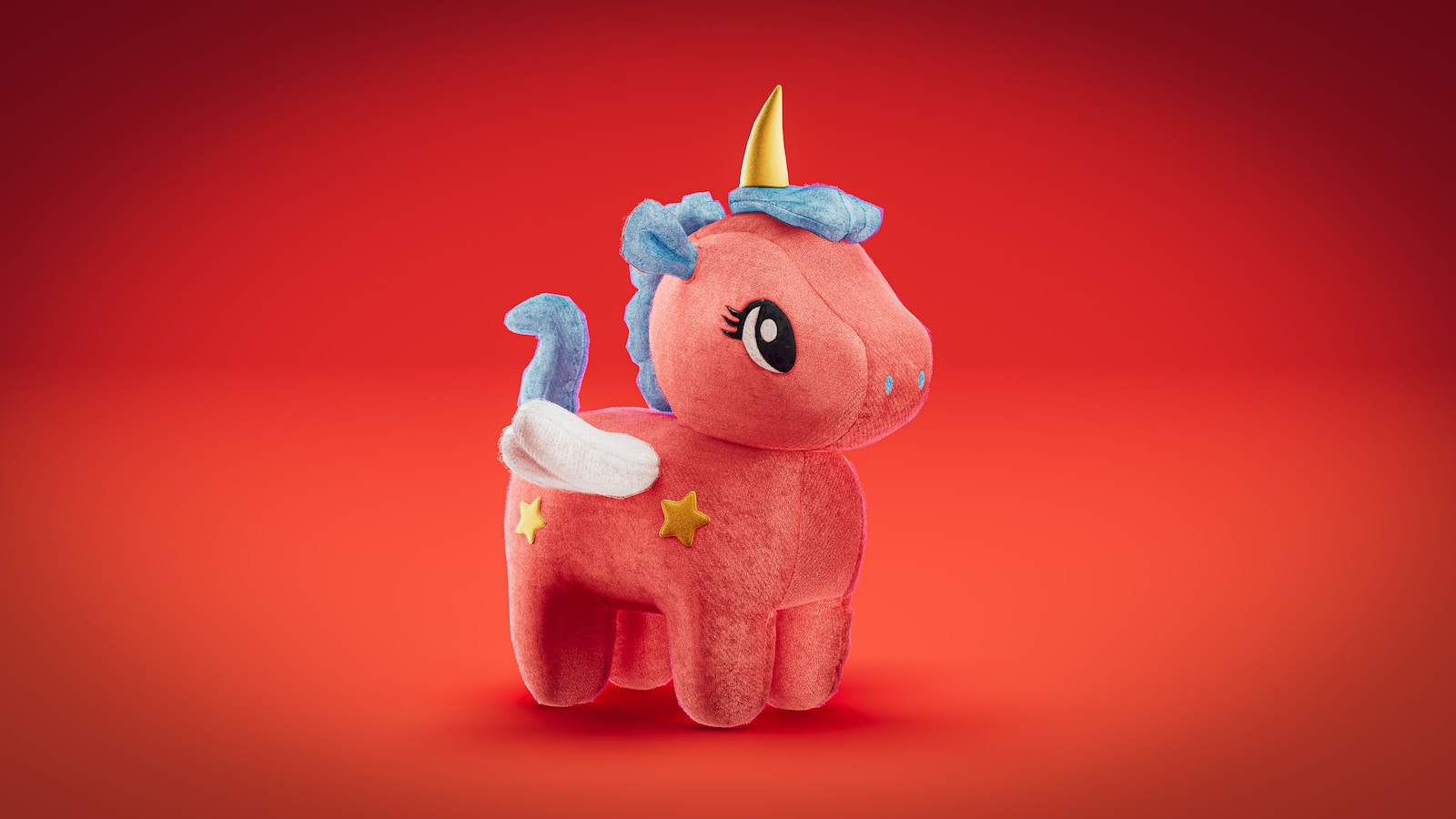 a pink stuffed animal with a gold horn on its head