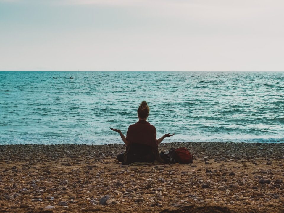 person doing yoga on seashore during daytime