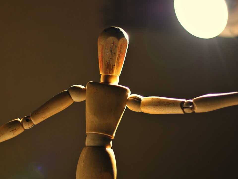 a wooden toy standing in front of a light