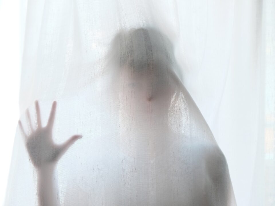woman holding behind curtain