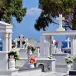 a bunch of white graves with flowers on them