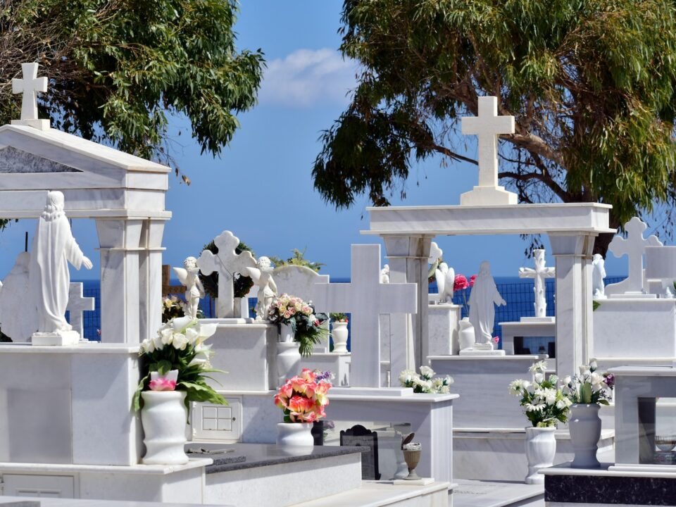 a bunch of white graves with flowers on them