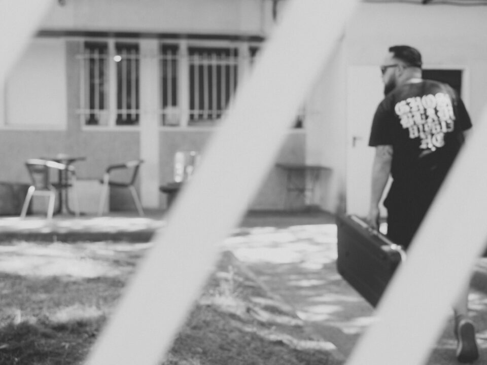 grayscale photography of man carrying case