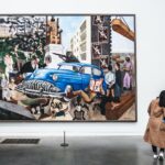 two persons looking at wall art