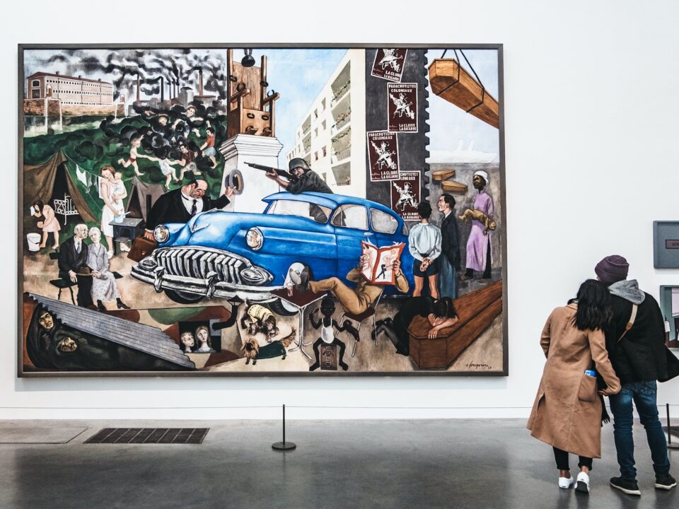 two persons looking at wall art