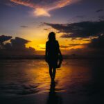 silhouette of woman standing on seashore