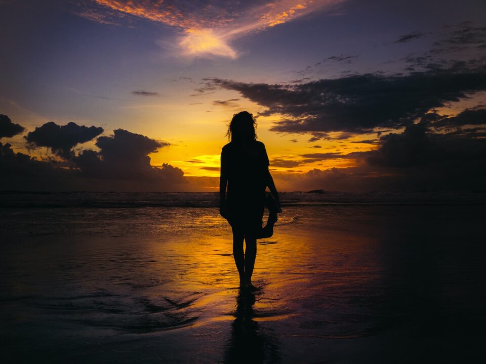 silhouette of woman standing on seashore