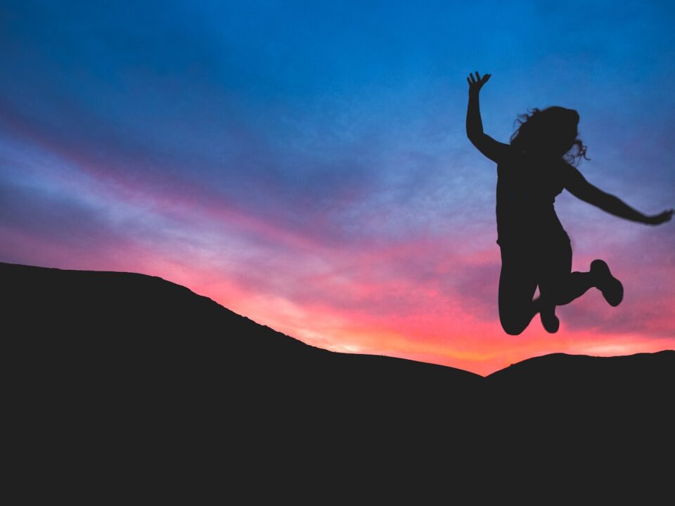 silhouette of person jumping during dawn