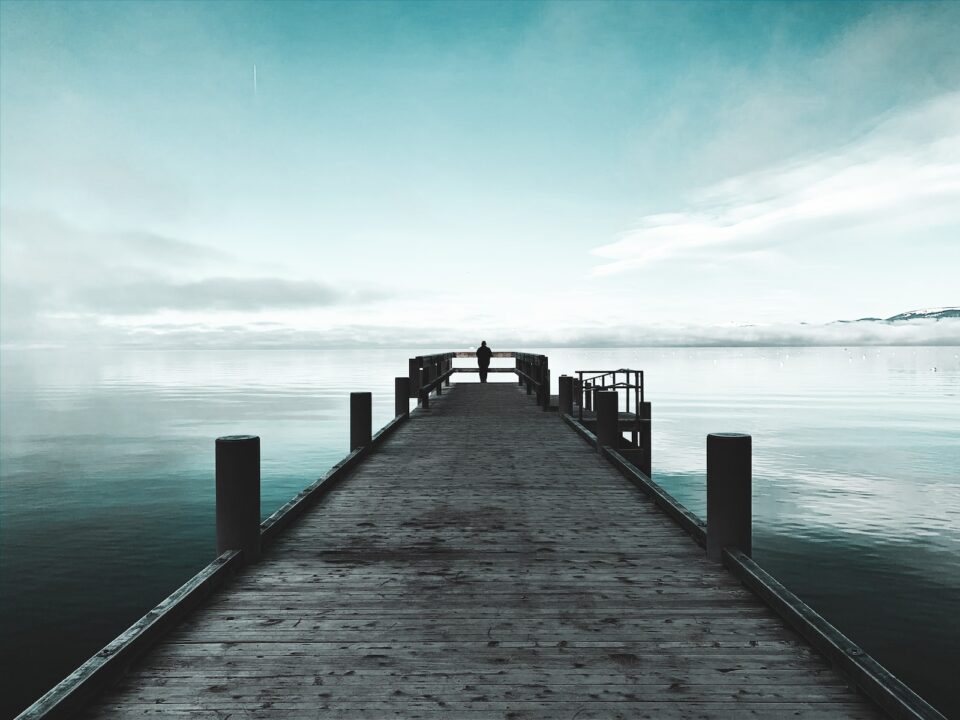 brown wooden dock on sea under blue sky during daytime