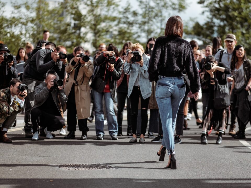 woman walking taking photo by people