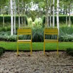 two yellow chairs in a garden