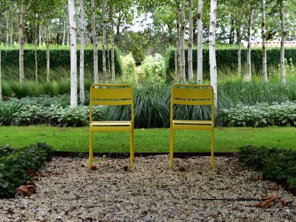 two yellow chairs in a garden