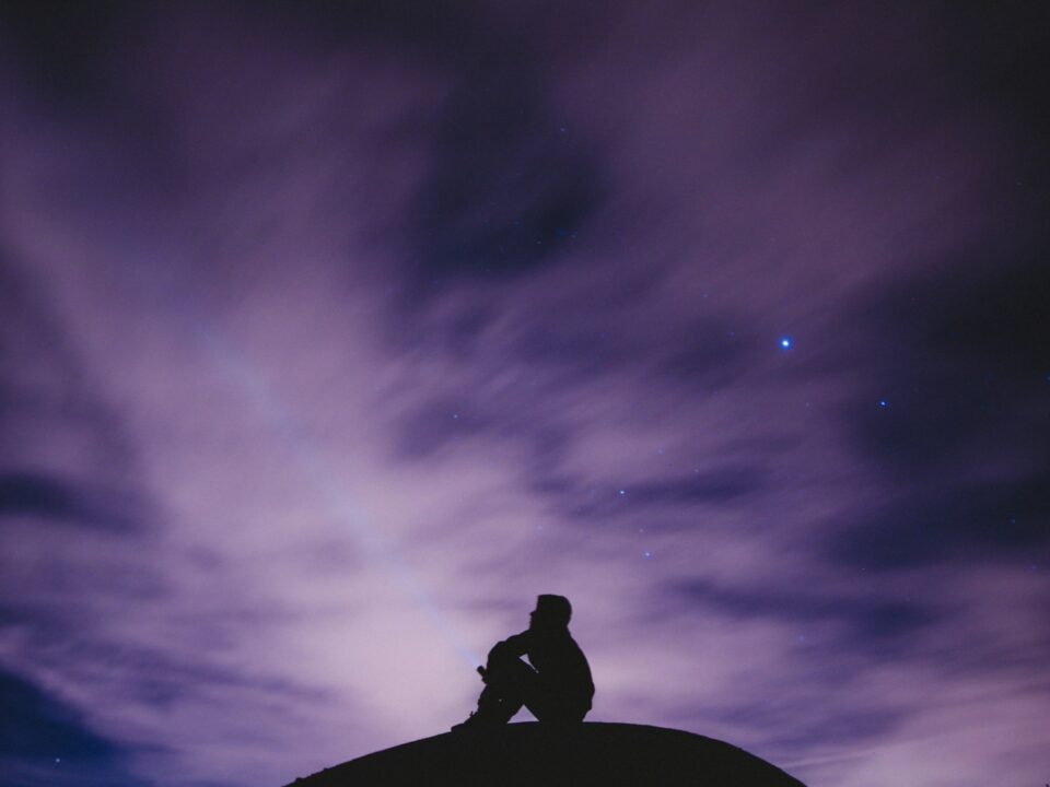 person sitting on black surface looking to sky