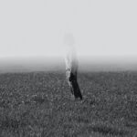 grayscale photo of person standing on field