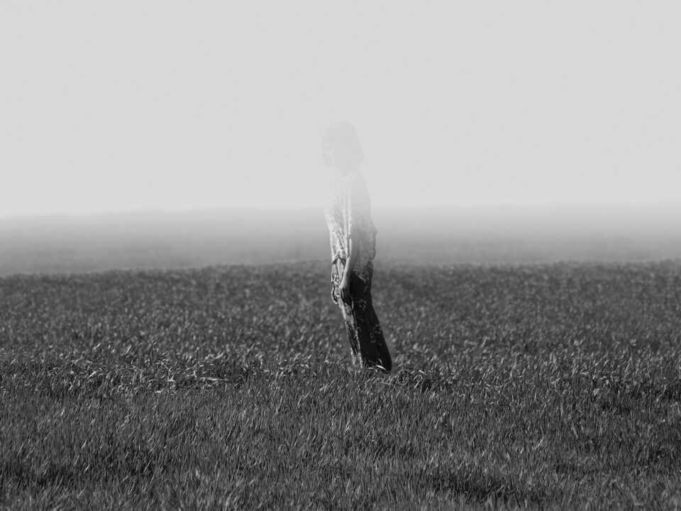 grayscale photo of person standing on field