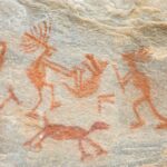 a rock painting of people and animals on it