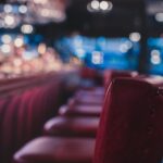 a row of red chairs sitting in front of a bar