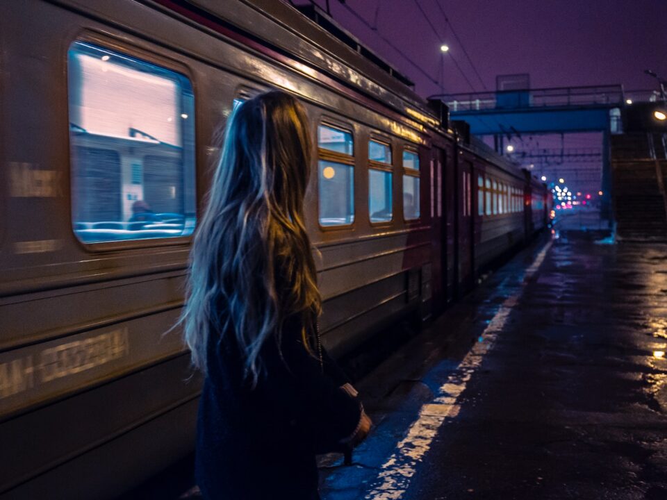 woman standing beside gray train
