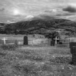 grayscale photo of wooden fence on grass field