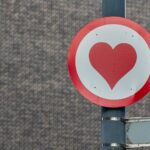 a red and white sign with a heart on it