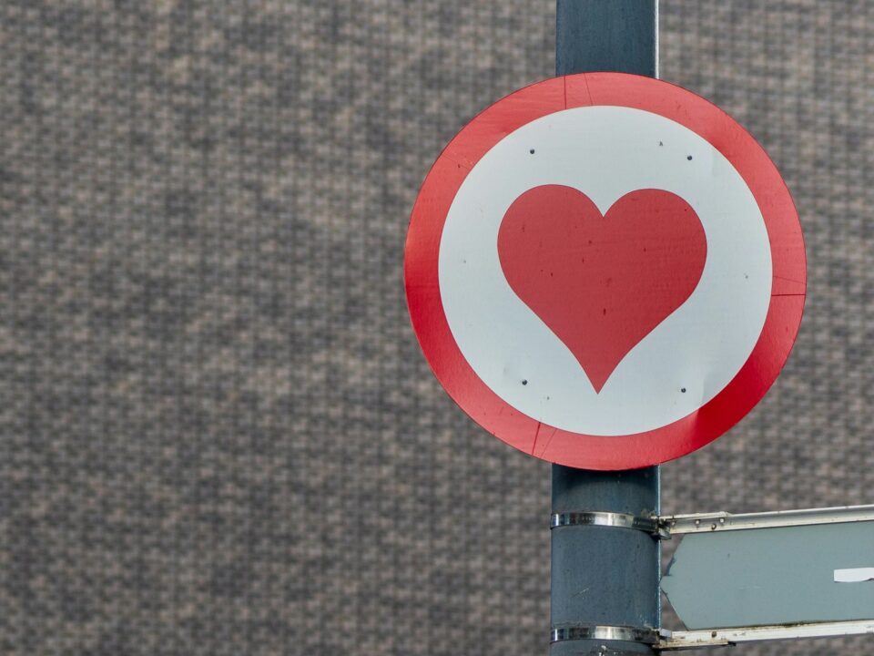 a red and white sign with a heart on it