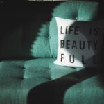 white and black Life is beautifull throw pillow on top of sofa