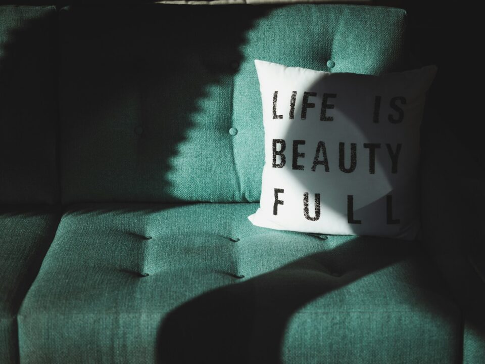white and black Life is beautifull throw pillow on top of sofa