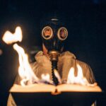 person wearing gas mask holding fire