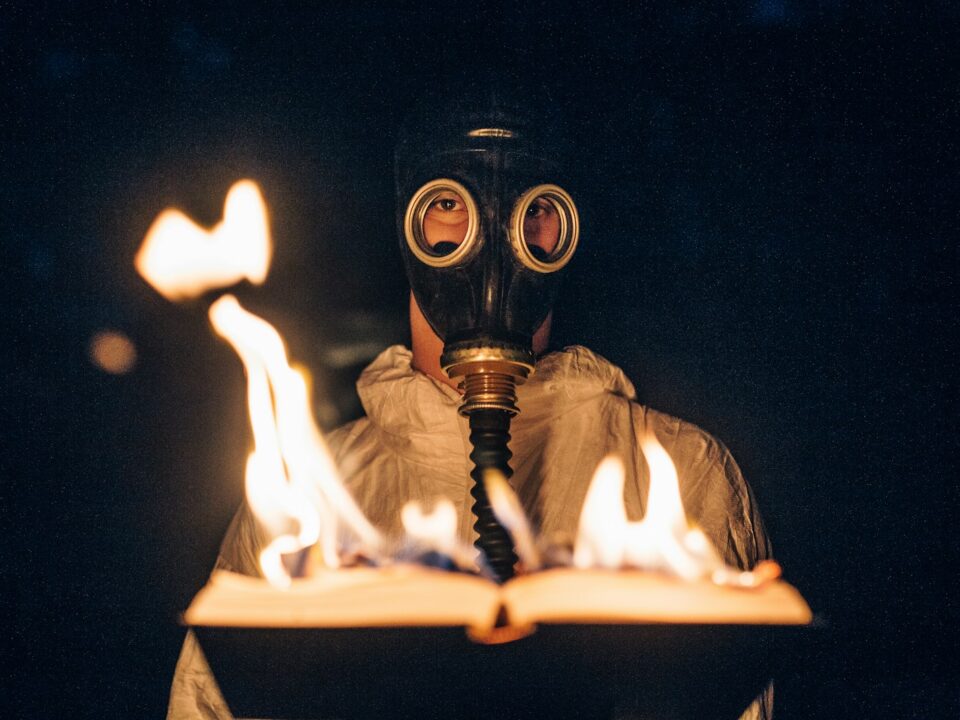 person wearing gas mask holding fire