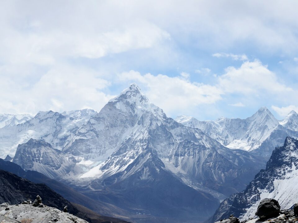 aerial photography of mountain range covered with snow under white and blue sky at daytime