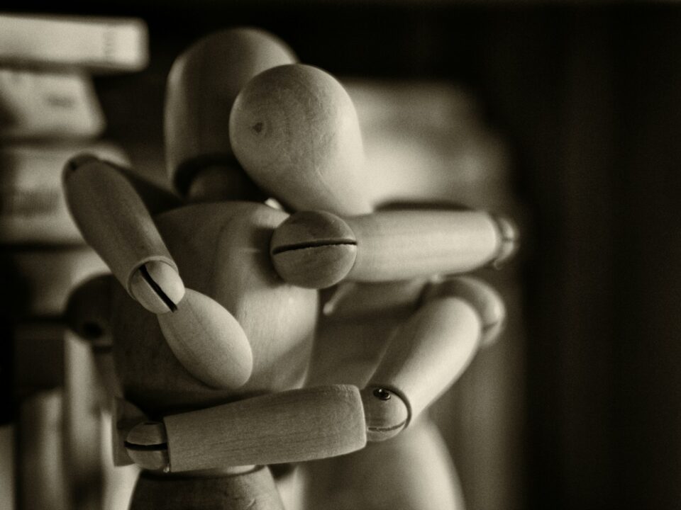 two wooden dummy hugging figures
