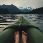 person on top of green kayak