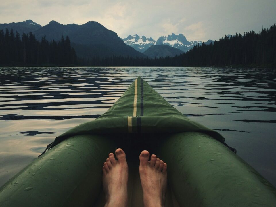 person on top of green kayak
