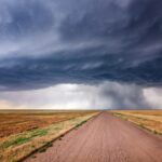 brown dirt road under gray clouds