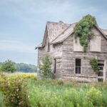 grey wooden house on green grass field during daytime