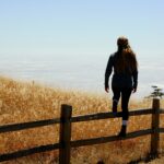 woman jump on brown fence