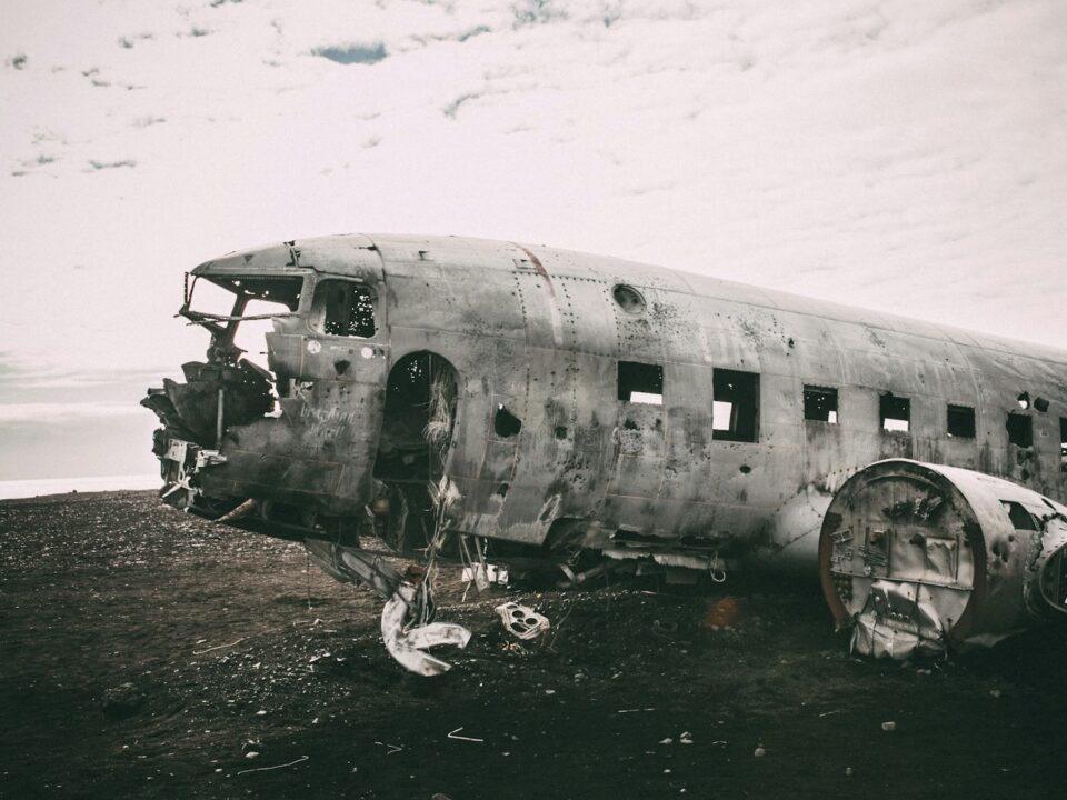 grayscale photo of abandoned airliner in open field