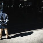 a man standing on a sidewalk in front of a building