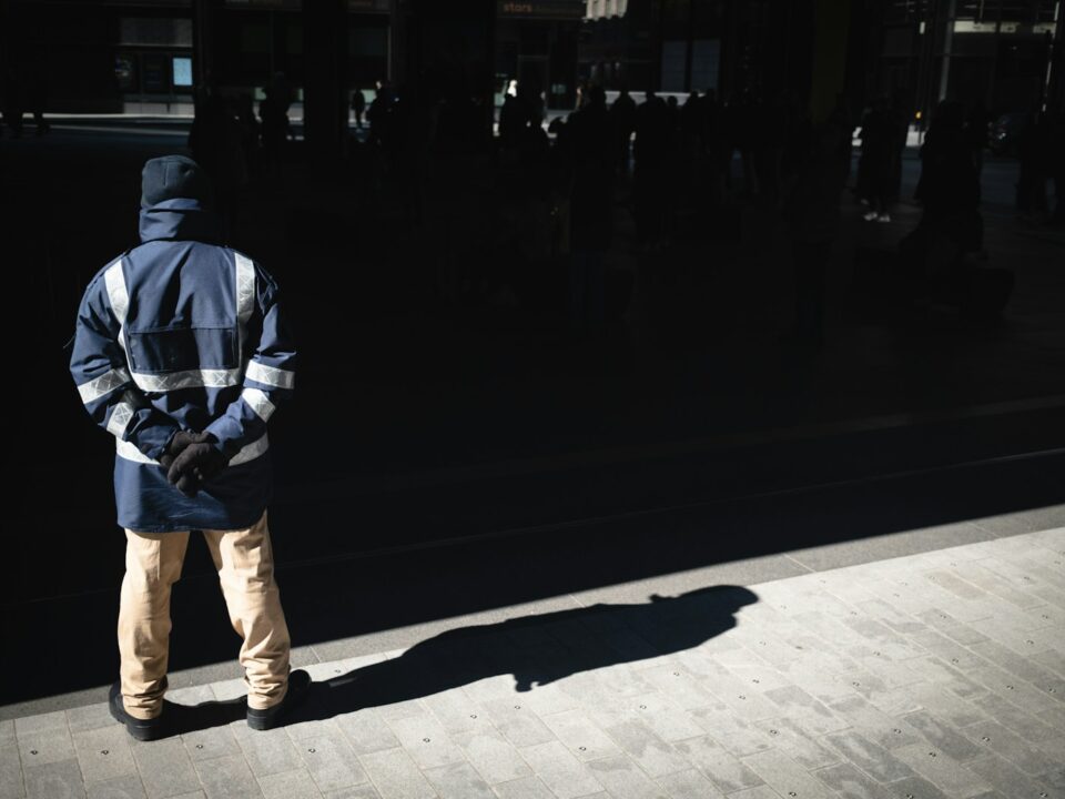 a man standing on a sidewalk in front of a building