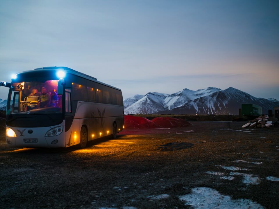 white and black bus running near the mountain