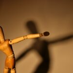 a wooden toy with a long shadow on a wall